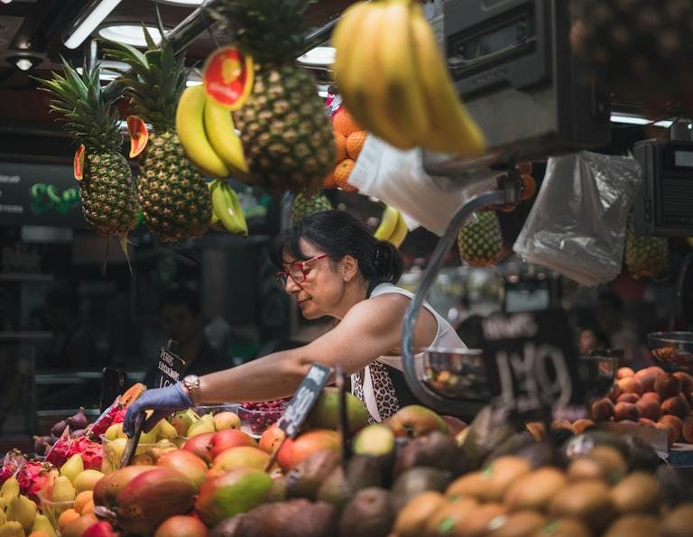 Una donna in un mercato di frutta e verdura.