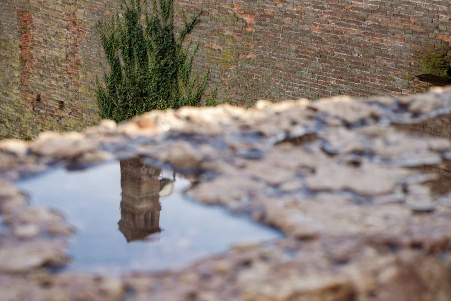 Torre riflessa in una pozzanghera d'acqua a Verona dopo una giornata di pioggia