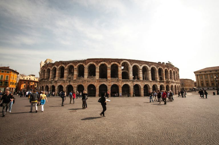 L'Arena di Verona durante una giornata di sole primaverile con molti turisti.