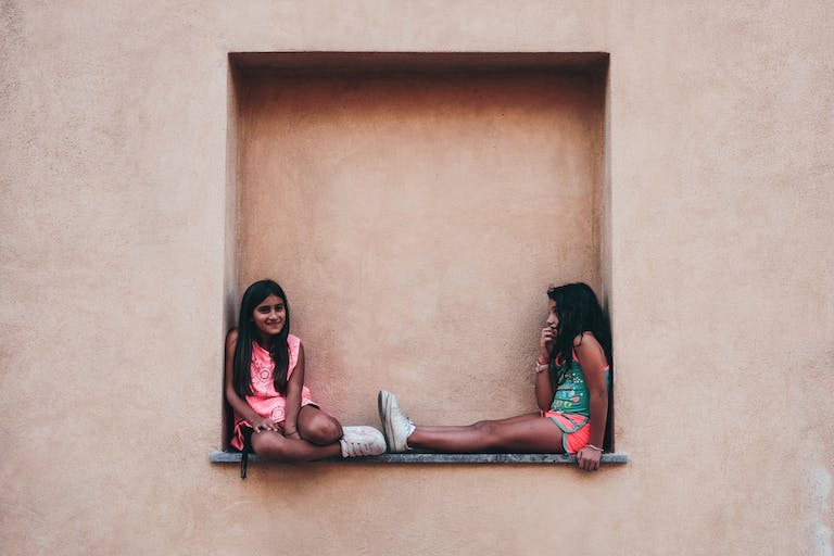 Due ragazze a Palermo sedute in un edificio.