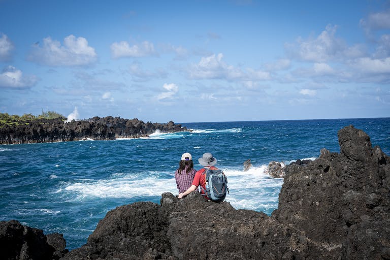 couple on rocks overlooking the ocean