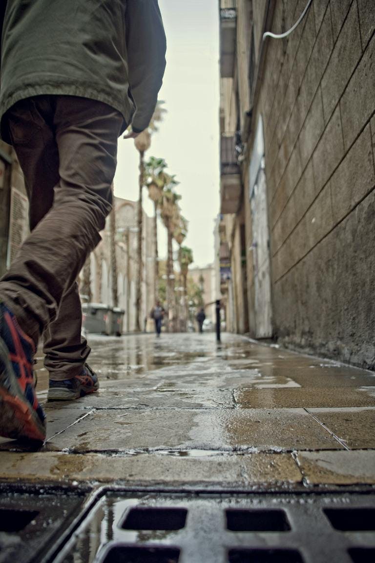 Uomo che cammina in una giornata di pioggia per le strade di Barcellona.